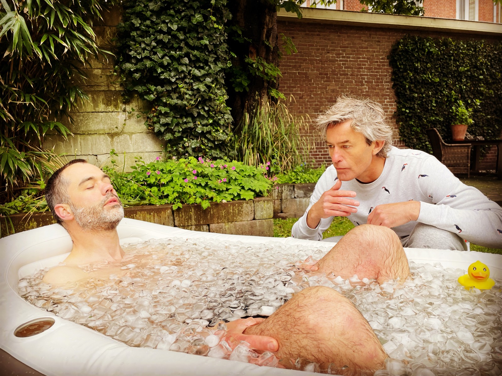 Jeroen begeleidt een deelnemer die in het ijsbad zit, met rustige aanwijzingen over de ademhaling.