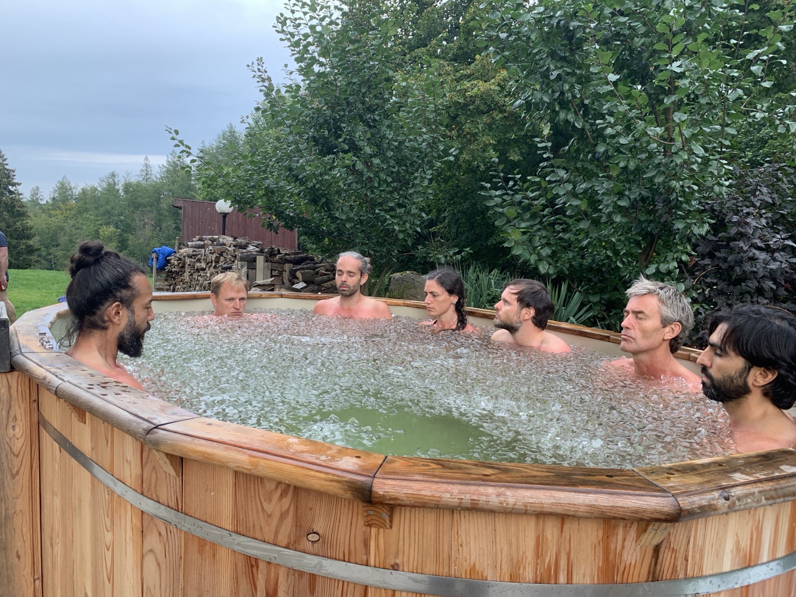Een groep deelnemers samen in een koud bad in de buitenlucht.